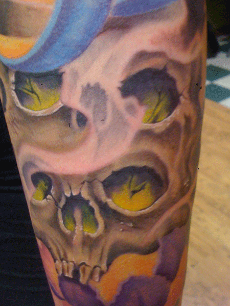 Close up of freehand drawn double stacked skulls in 1/4 sleeve. Full color tattoo.
